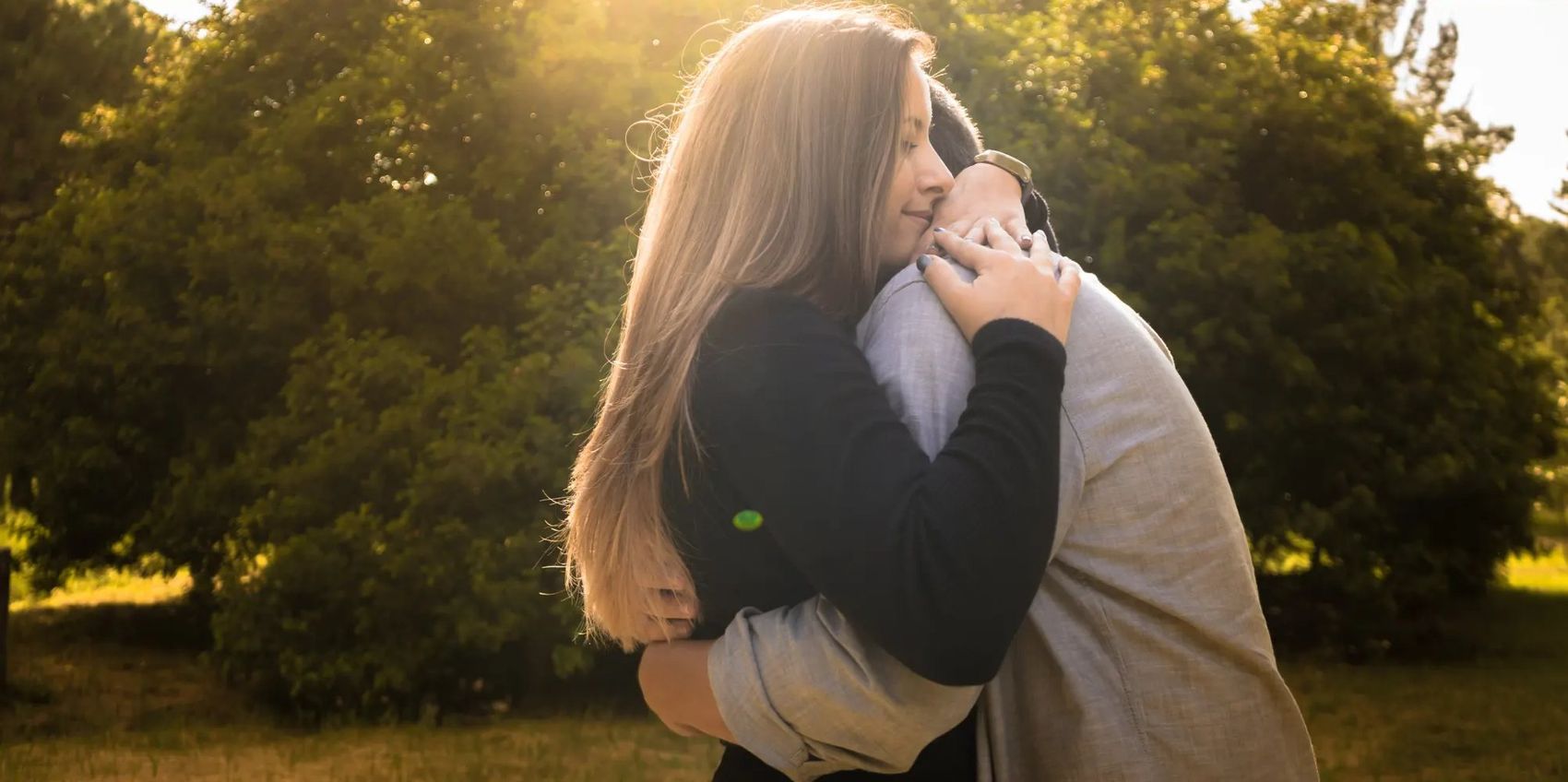 A couple holding each other close in warm evening light